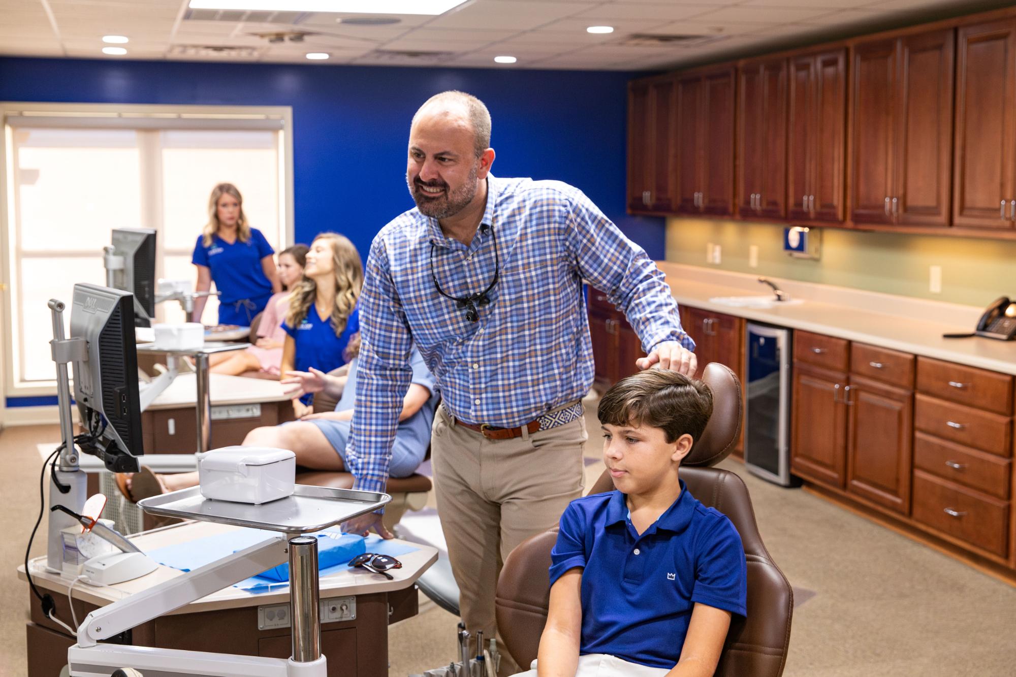 Dr. Ryan Cox of Ryan Cox Orthodontics checking on a young patient in the treatment bay, an orthodontist serving Calhoun, GA